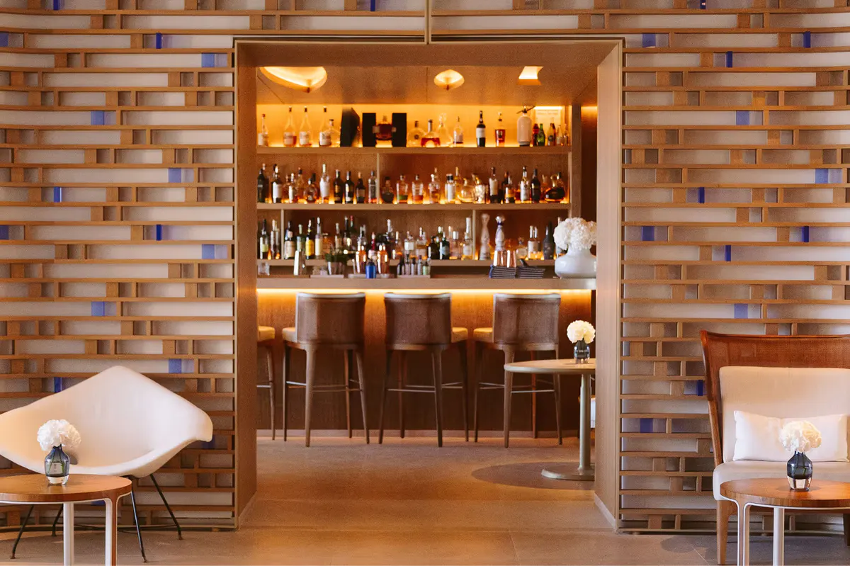Brick bar entrance with backlit bottles and warm lighting