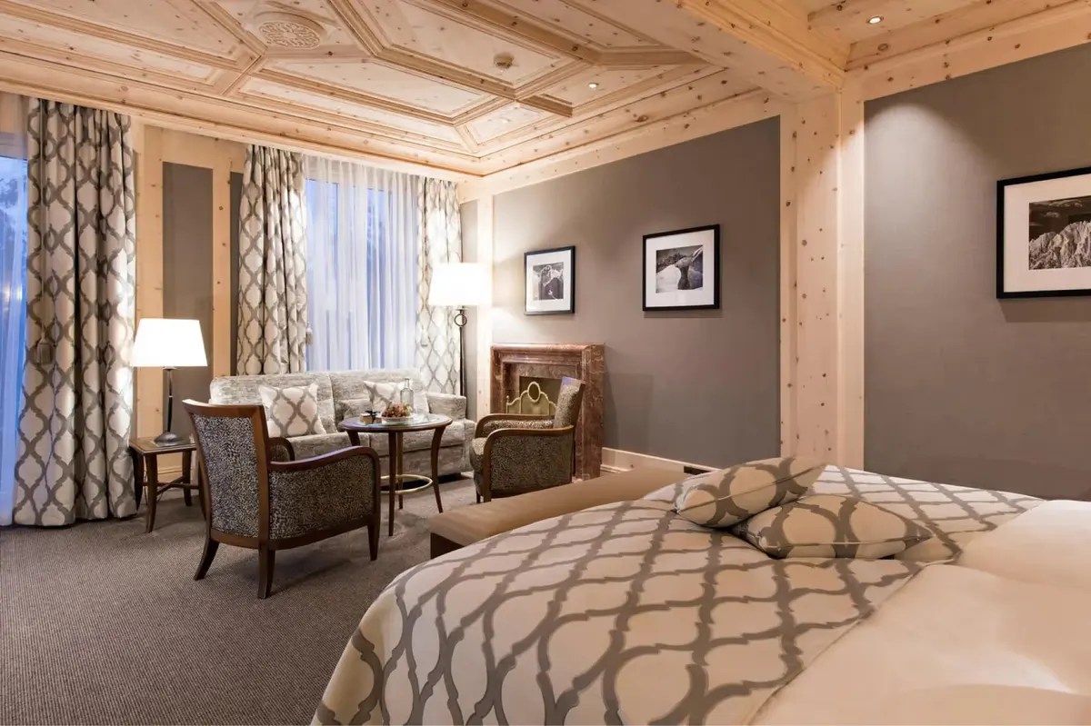 A bedroom with wood-beamed ceiling and contemporary furnishings in neutral tones