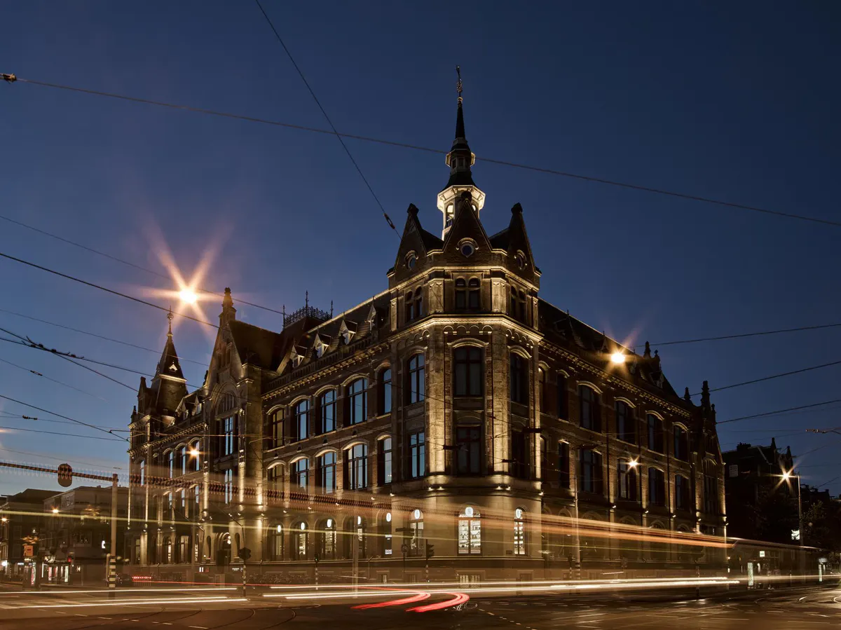 The 19th-century landmark building exterior lit at dusk with its distinctive architecture and turrets