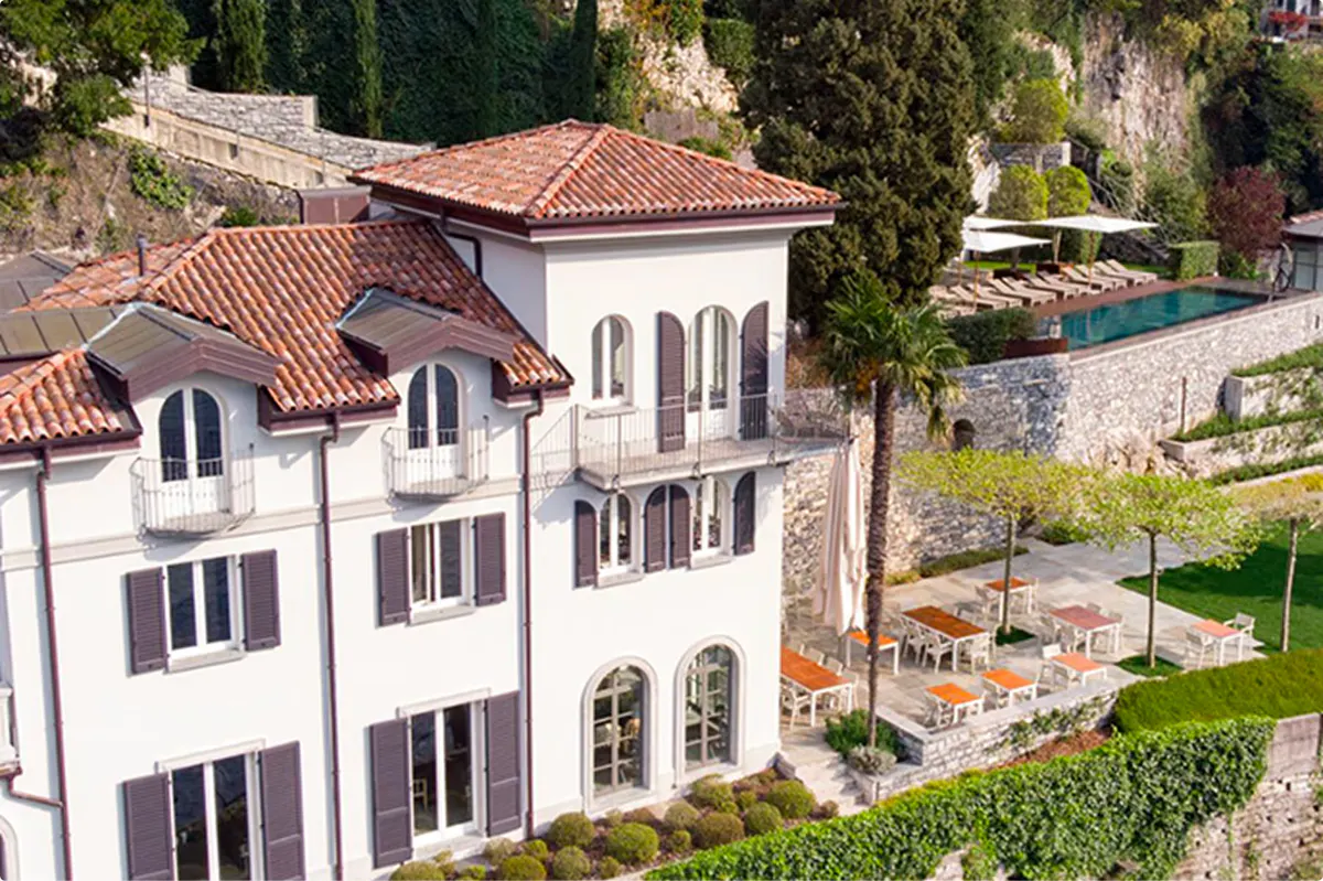 Whitewashed villa on hillside surrounded by landscaped grounds