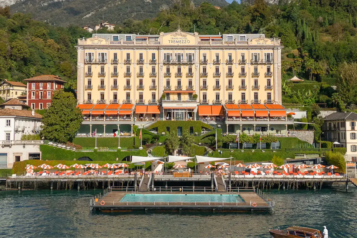 The palatial facade of the Art Nouveau hotel with orange awnings facing Lake Como