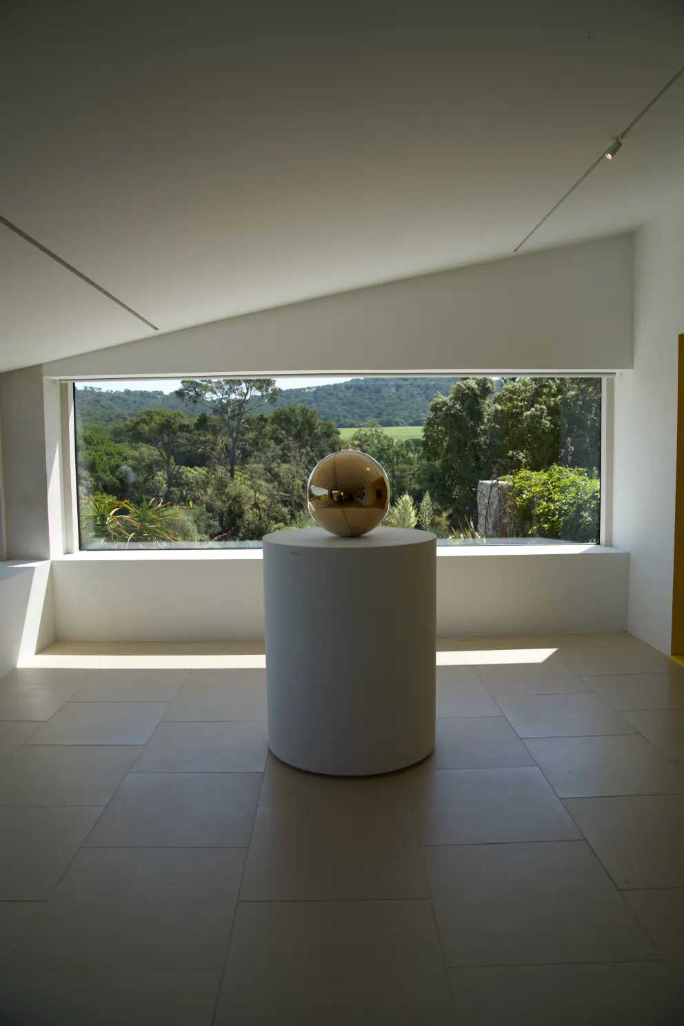 A gilded sphere on a pedestal in the gallery at the Fondation Carmignac