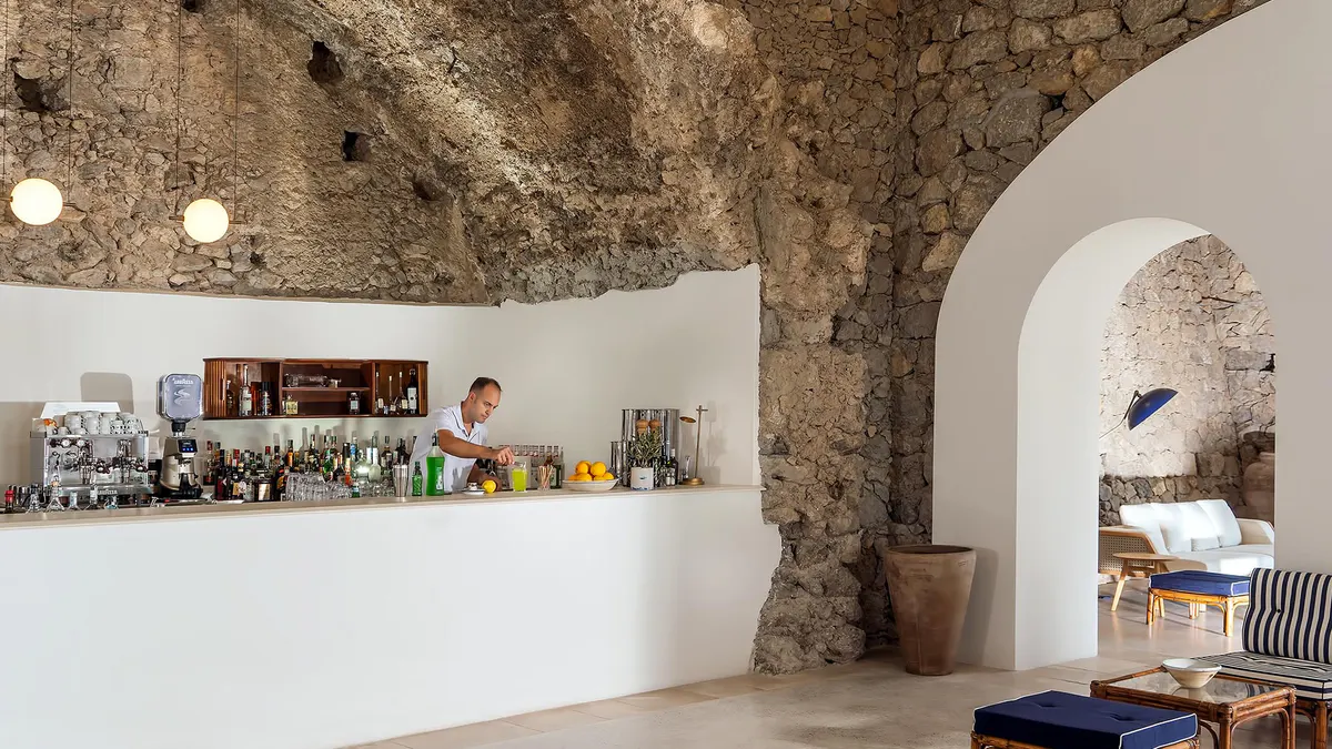Bar counter in stone-walled space with exposed masonry and display shelving