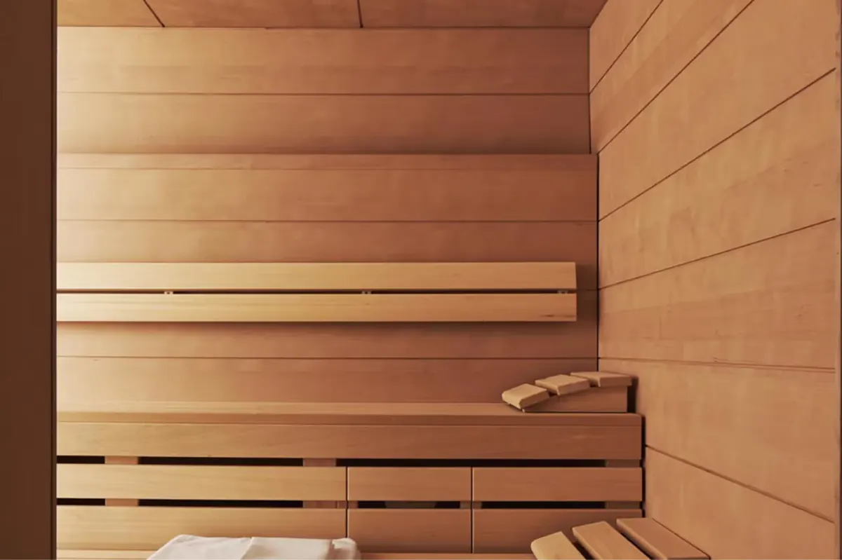 A sauna interior with light wood construction and parallel benches