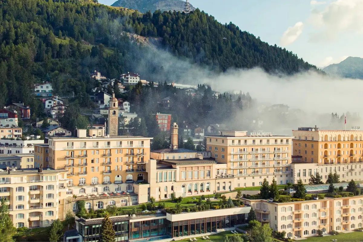The hotel’s honey-colored facade overlooks Lake St. Moritz with Alpine peaks beyond