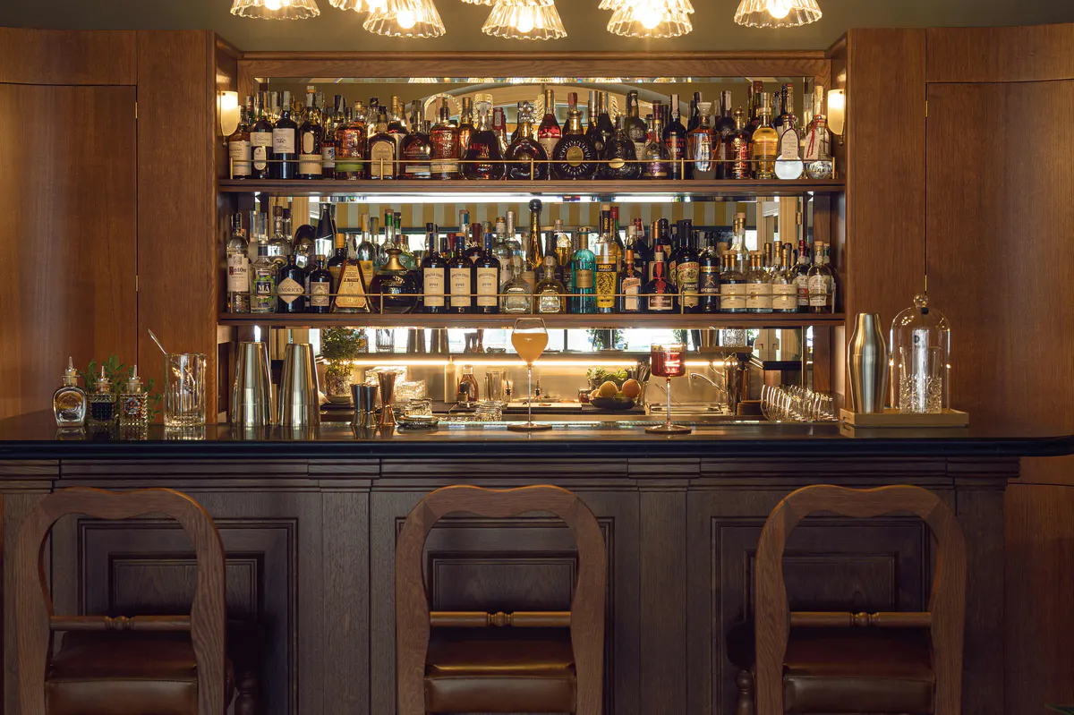 Bar with illuminated shelves of bottles and glassware