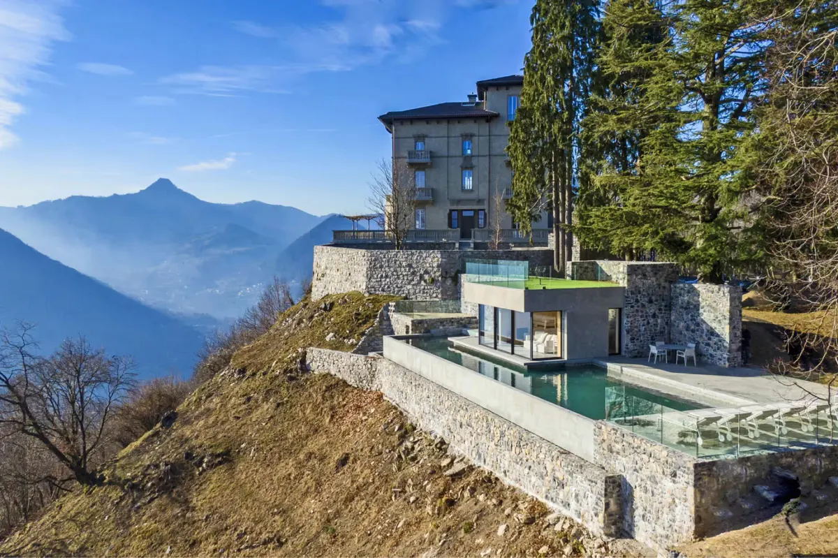 The villa on a hillside with views across the lake to distant mountains