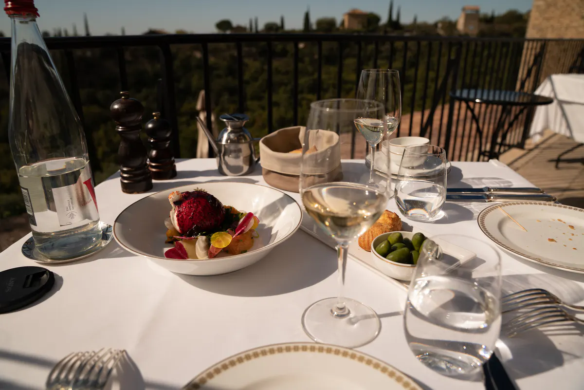 Formal place setting with wine glass and water glass on white tablecloth