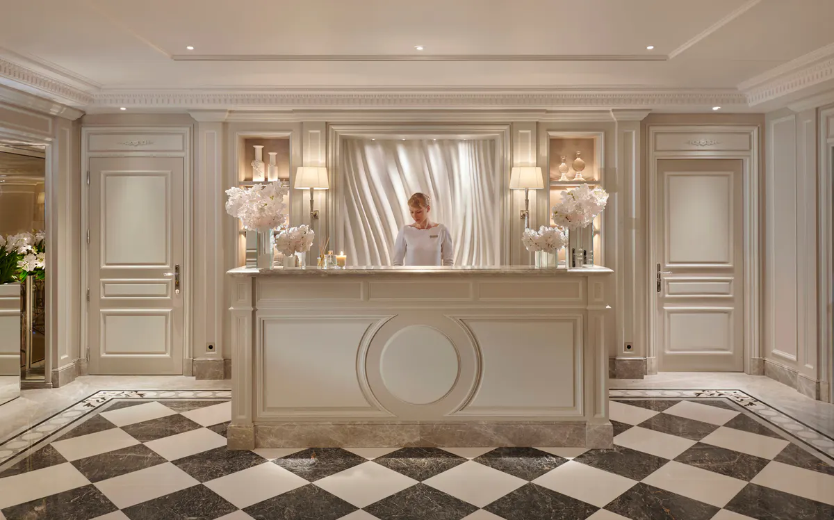 A spa reception area with cream walls, crown molding, and glass shelving