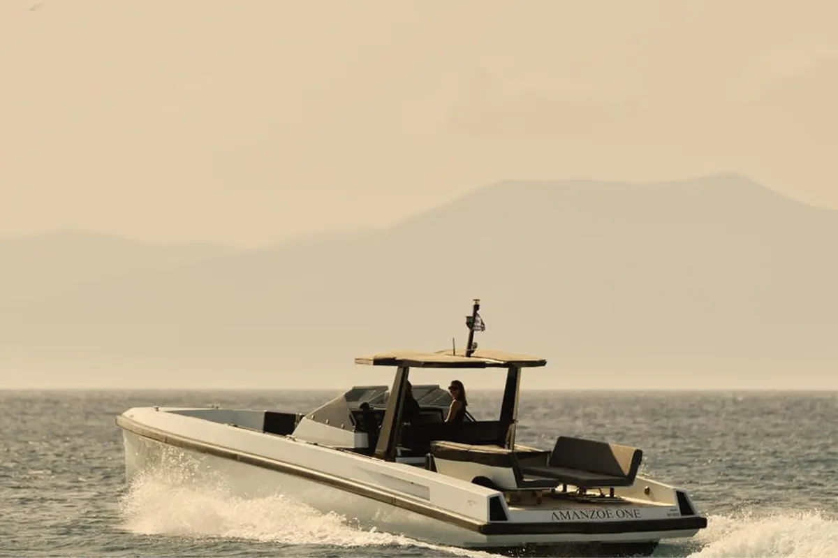 Motorboat departing from shore with mountains in distance