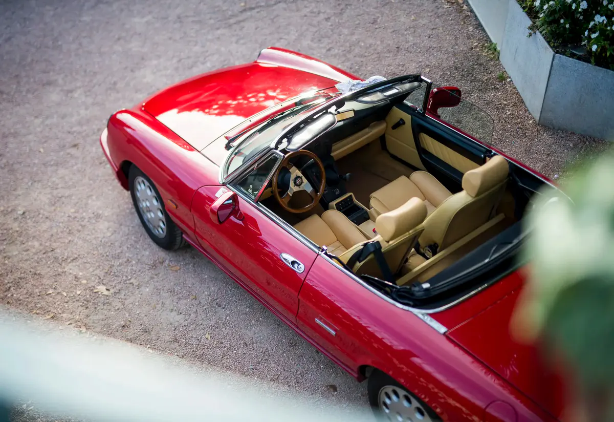 Red vintage convertible car parked near the hotel