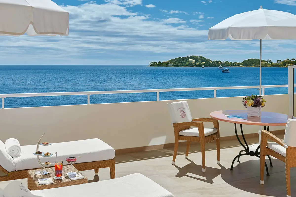 Balcony lounge with white sun loungers and Mediterranean vista