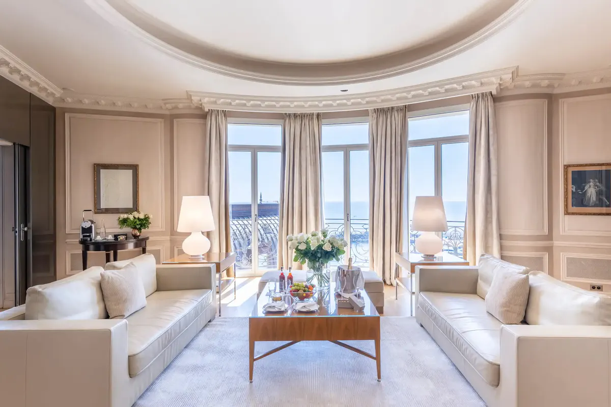 Formal sitting room with dual cream sofas, arched ceiling and wide glass doors to sea view