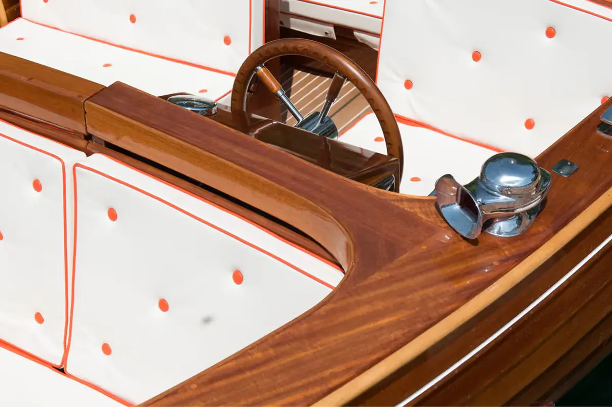 A detail of a boat’s interior with wooden railings and rope fittings