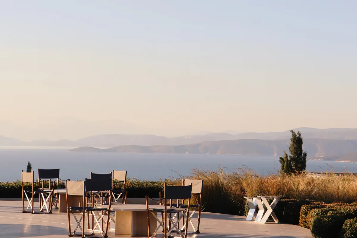 Sunset outdoor dinner setup with fire pit and seascape backdrop