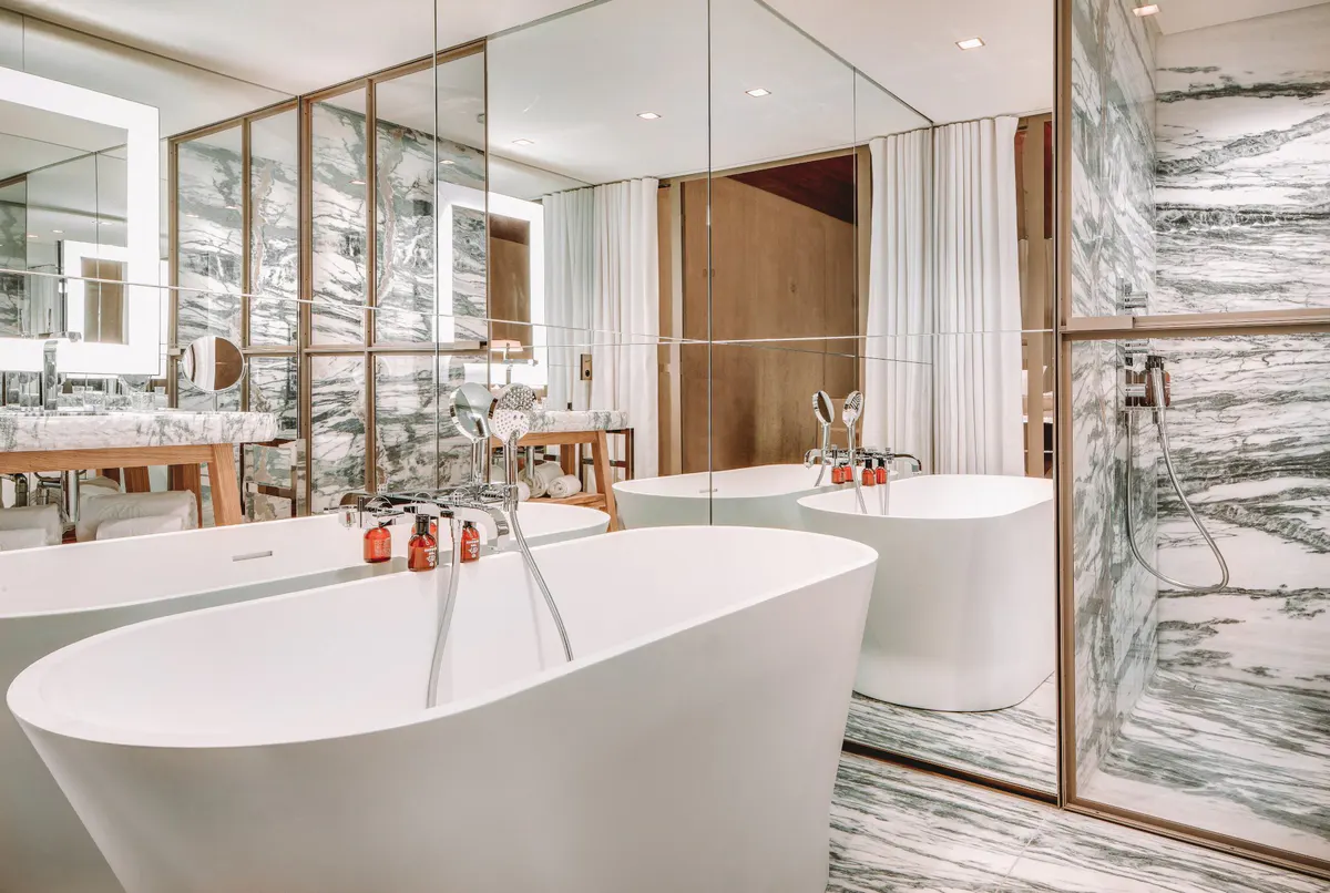 Spa bathroom with white soaking tub and mirrored wall accents