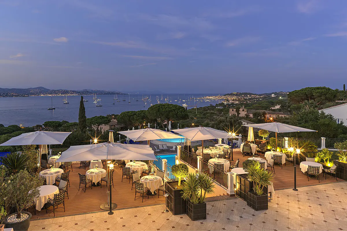 Evening terrace reception with cream market umbrellas and landscaped gardens