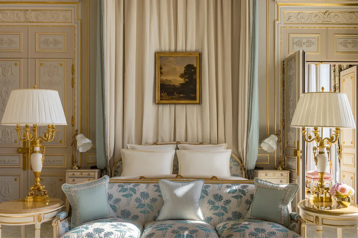A cream suite with striped curtains, gilt ceiling details, and upholstered seating arrangement