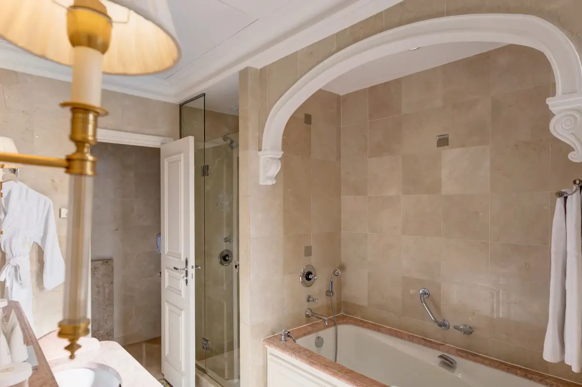 Luxury bathroom with deep soaking tub, arched archway and marble surround