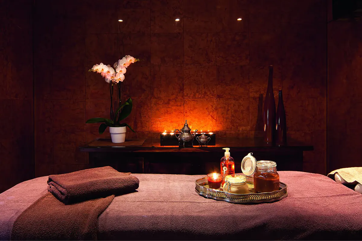 Spa interior with burgundy tones, heated massage table, and ambient lighting