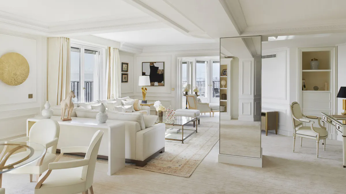 An open suite with mirrors, cream furnishings, and pale wood flooring throughout