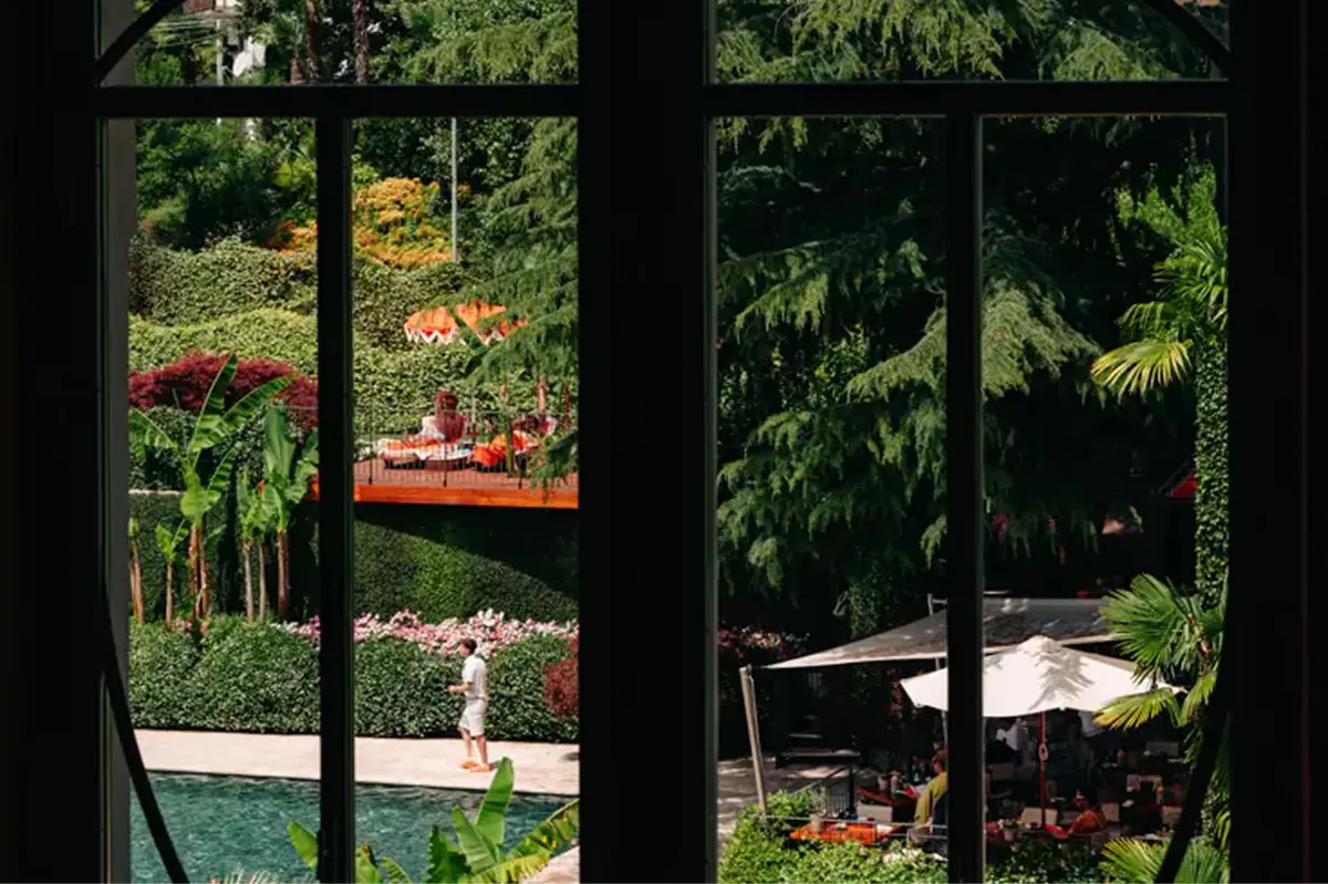 Garden view through arched windows showing flowering landscape