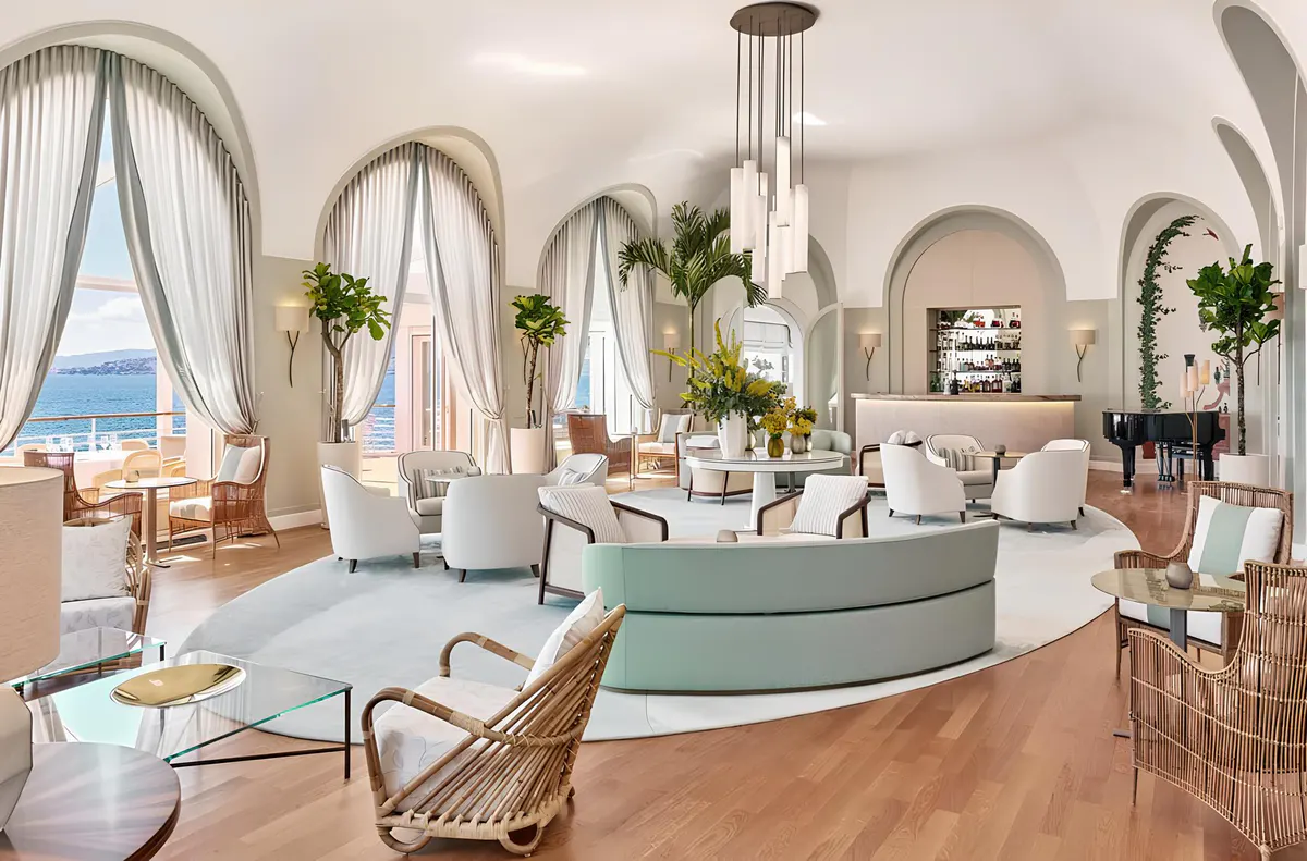 A light-filled circular reception hall with curved seating, arched doorways, and sea-view windows