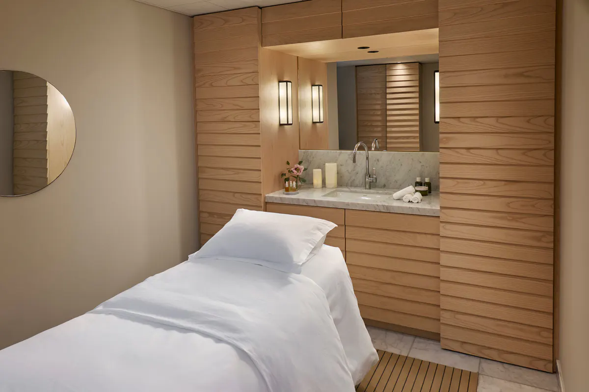 Wellness treatment room with wooden accents and spa massage bed