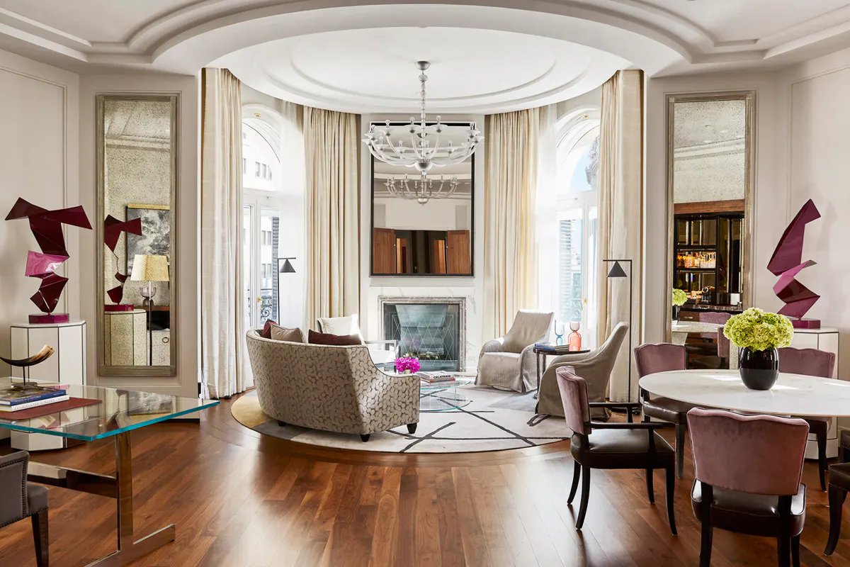 Suite living area with curved ceiling, burgundy accents, hardwood floors, and ornate furnishings