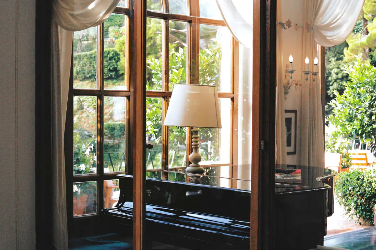 Dark wooden doors with brass handles and arched transom opening onto light interior