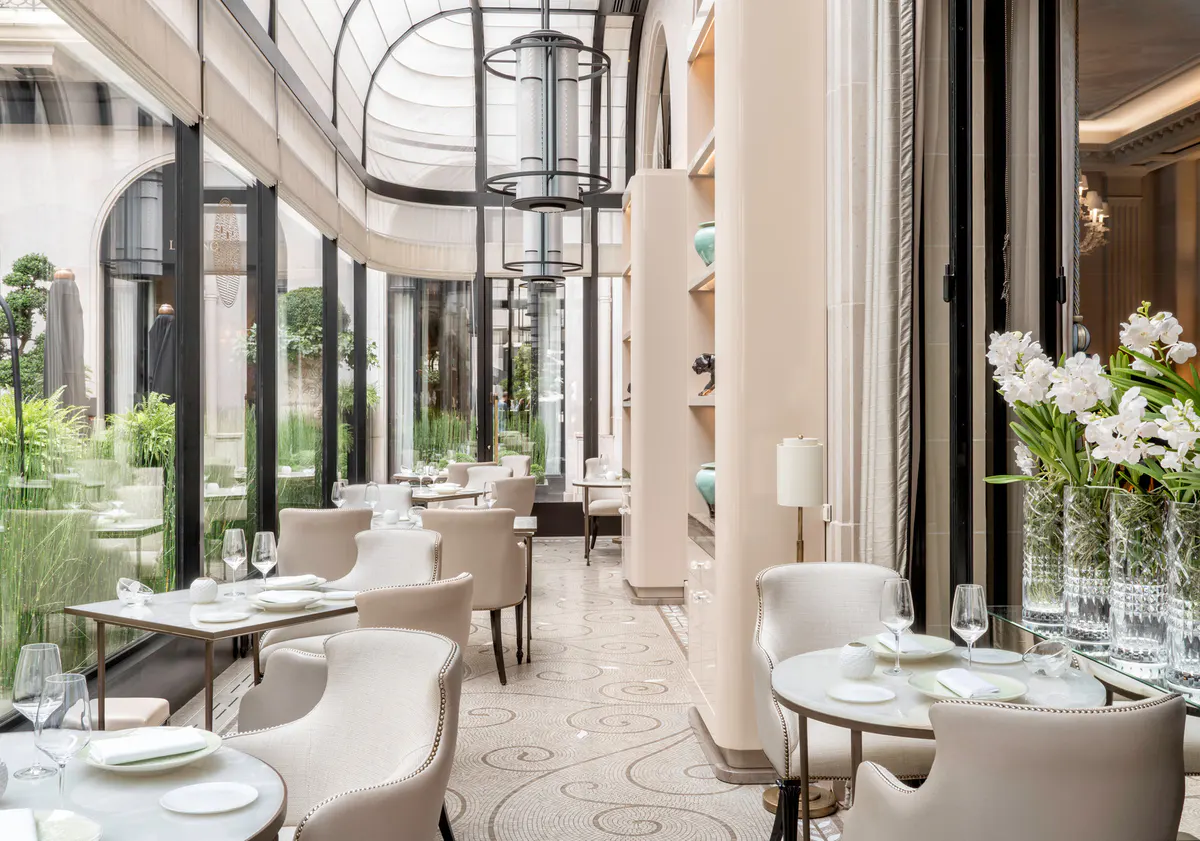 A dining room with tall arched ceilings, elegant table settings, and fresh florals