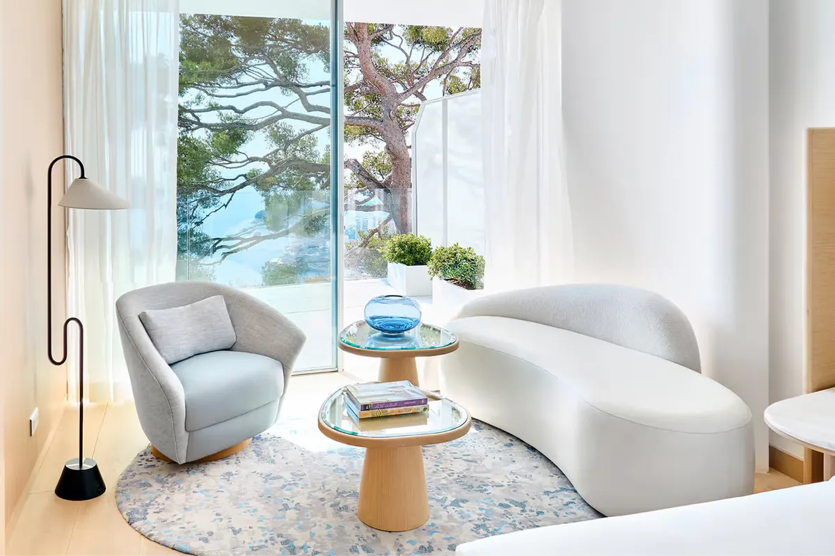 Bedroom with light wood accents and window seating overlooking water