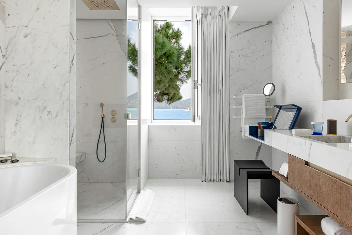Marble bathroom with walk-in shower and coastal light